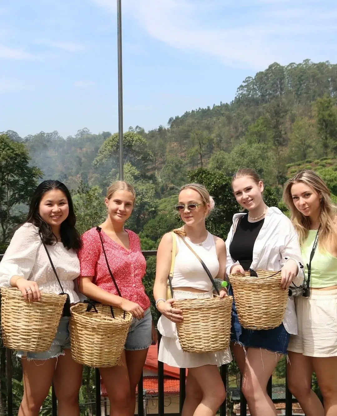 Group of travellers holding woven baskets on a green hillside