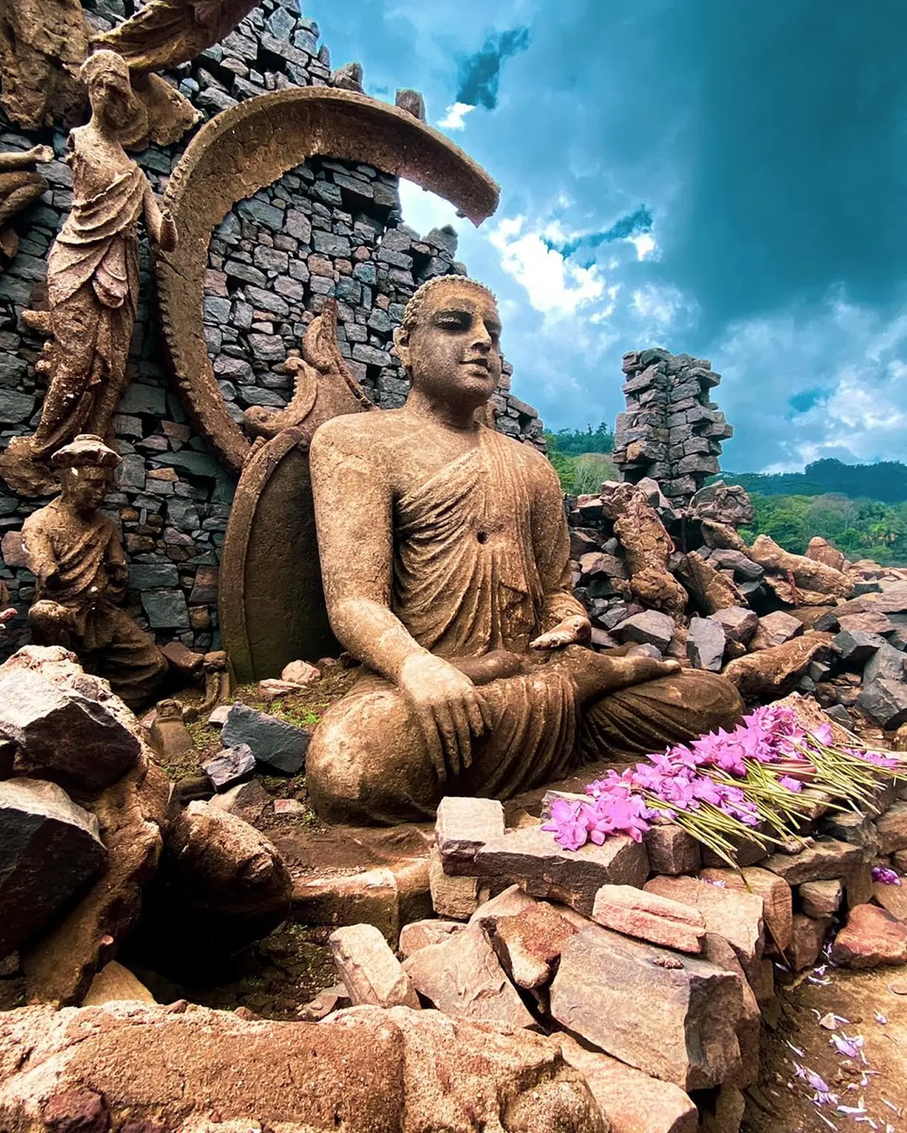 Seated Buddha statue among ancient stone ruins